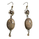 Pair of earrings with oval stones and dangling elements on a white background