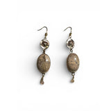 Pair of earrings with brown oval stones on a white background