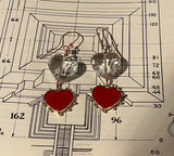 Heart-shaped earrings with red centers and clear heart-shaped drops on a technical drawing background.
