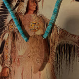 Traditional Native American headdress with turquoise elements and feathers on a neutral background