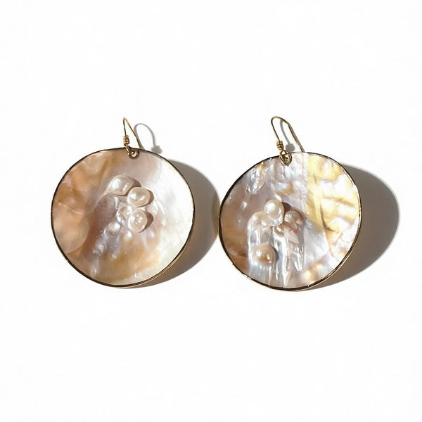 Pair of round earrings with pearl-like patterns on a white background