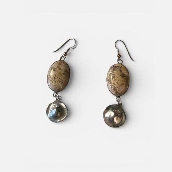 Pair of earrings with metallic stones on a white background