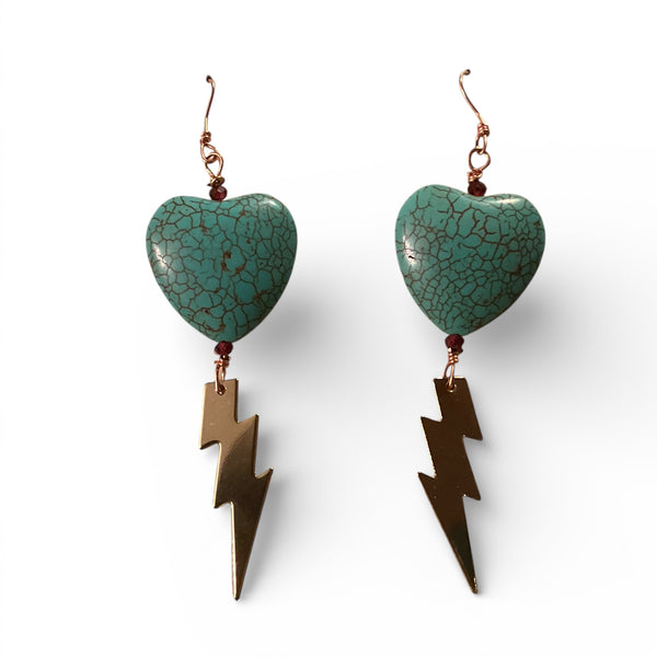 Turquoise heart-shaped earrings with bronze lightning bolt charms on a white background