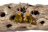 Yellow glass earrings on a piece of driftwood with text in the background