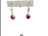 ruby earrings on earring stand on white background